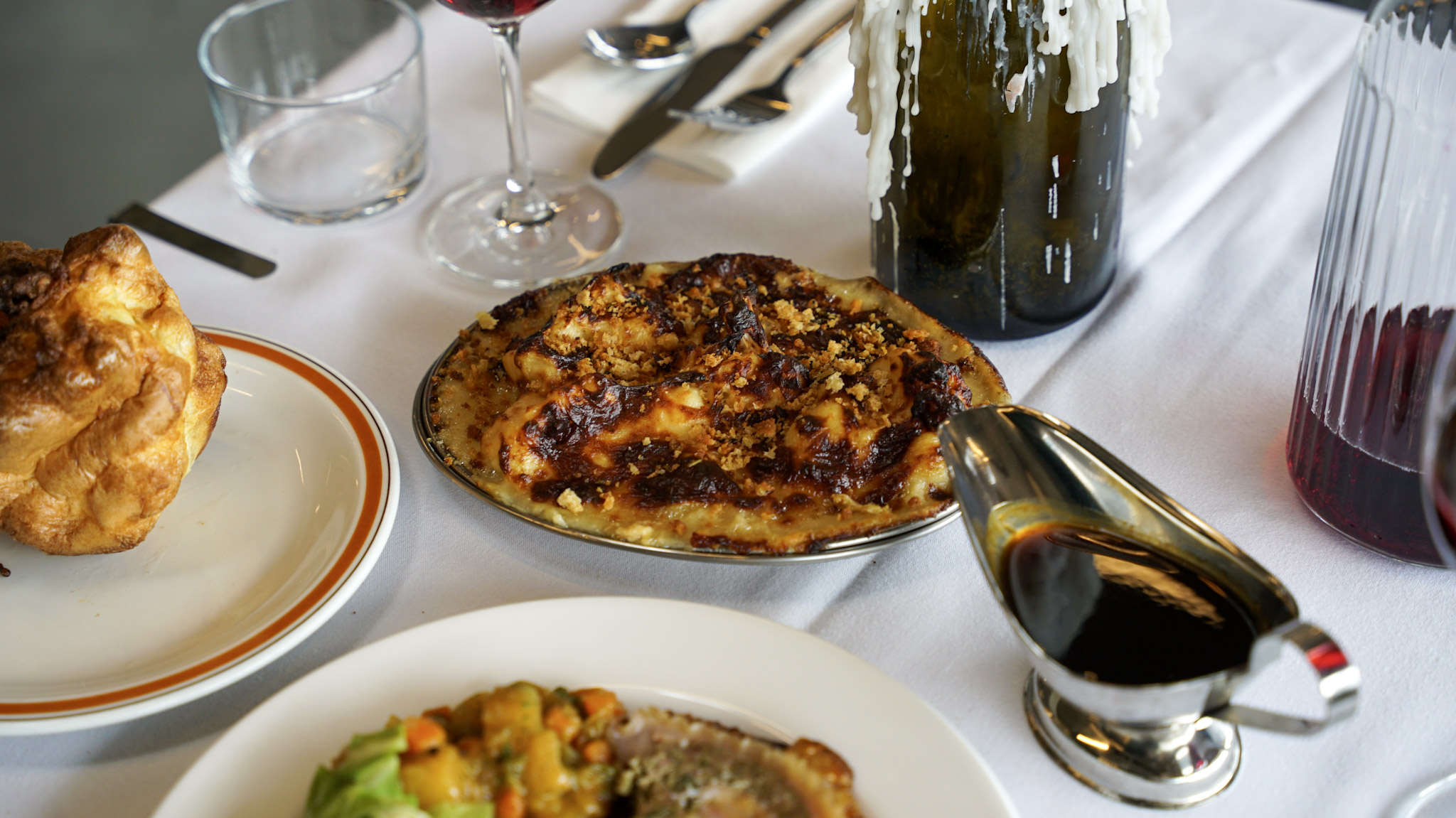 A Yorkshire pudding, cauliflower cheese and a boat of jus